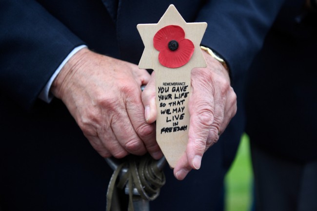 WWII British veteran Mervyn Kresh holds a poppy on an inscribed wooden Star of David during a remembrance ceremony at The Normandy American Cemetery in Colleville-sur-Mer on June 4, 2019, ahead of the 75th anniversary of D-Day. [Photo: AFP/Damien Meyer]