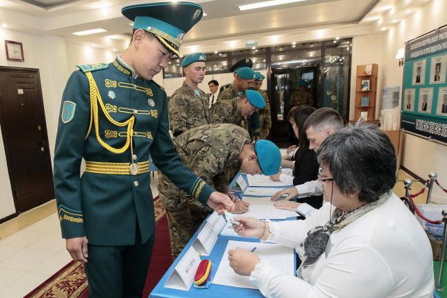 Kazakh servicemen receive ballots at a polling station during Kazakhstan's presidential elections in Nur-Sultan on June 9, 2019. [Photo: AFP/ Stanislav FILIPPOV] 