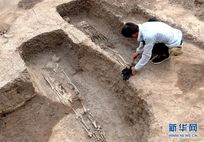 An archaeologist is cleaning a family tomb of ancient bronzeware artisans discovered in central China's Henan Province, June 5, 2019. [Photo: Xinhua]