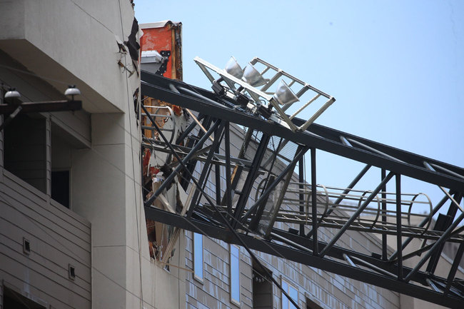 Officials respond to the scene after a crane collapsed into Elan City Lights apartments amid severe thunderstorms, Sunday, June 9, 2019, in Dallas. [Photo: AP]