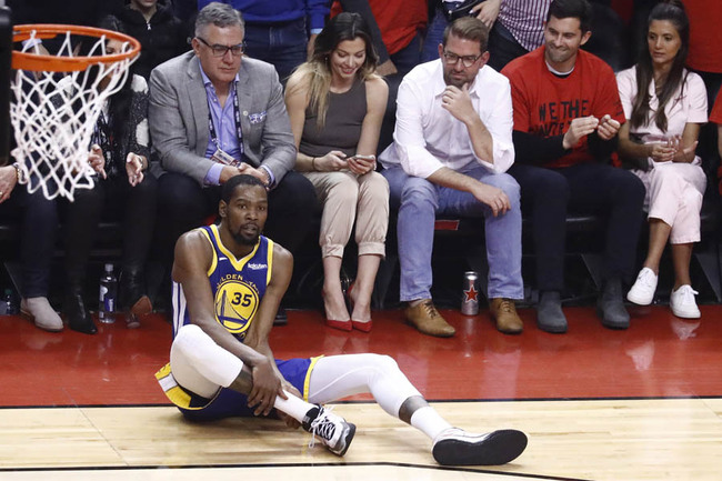 Golden State Warriors forward Kevin Durant holds on to his calf after injuring it in a play against Toronto Raptors center Serge Ibaka during the first half of the NBA Finals basketball game five between the Golden State Warriors and the Toronto Raptors at Scotiabank Arena in Toronto, Canada, 10 June 2019. [Photo: IC]