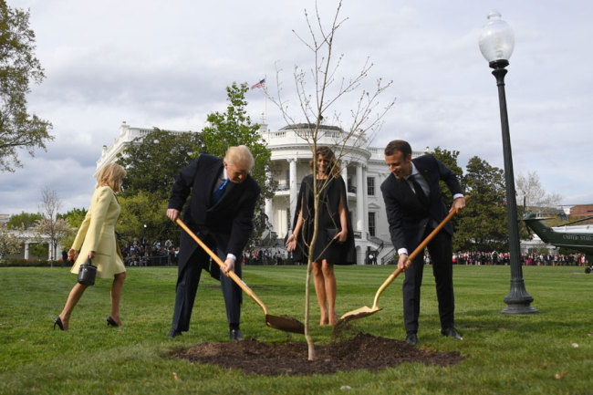 US President Donald Trump and First Lady Melania Trump participate in a tree planting ceremony with French President Emmanuel Macron and his wife Brigitte Macron on the South Lawn of the White House in Washington, DC, on April 23, 2018. [File Photo: AFP/JIM WATSON]