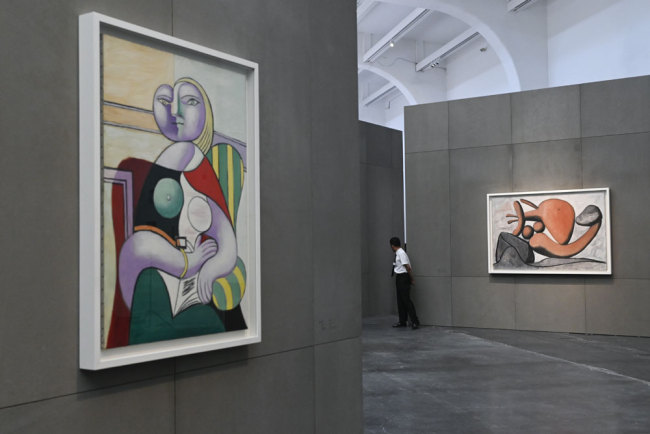 This picture taken on June 14, 2019 shows staff member looking back during an exhibition "Picasso Birth of a Genius" at an art gallery in Beijing. [Photo: AFP/Wang Zhao]