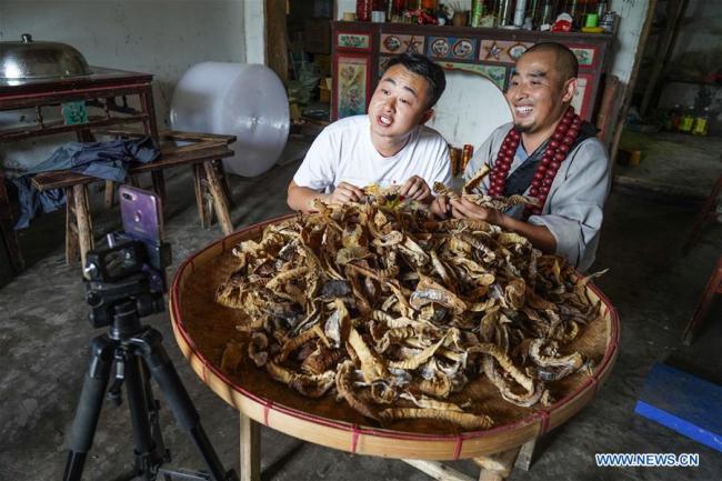 Jiang Jinchun (R) and his nephew Jiang Bin introduce dried bamboo shoots(笋干 sǔn gān) of their hometown during a live broadcast in Zaotian Village in Hengfeng County, east China's Jiangxi Province, June 19, 2019. [Photo: Xinhua]