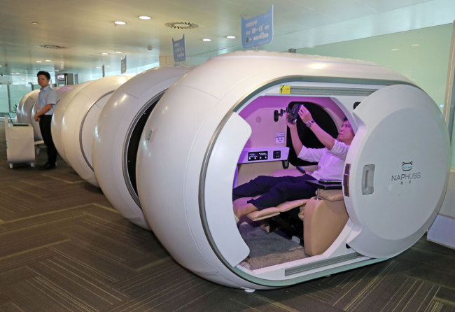 A man sits in a capsule at Terminal 3 at Hangzhou Xiaoshan International Airport on June 23, 2019. [Photo: IC]