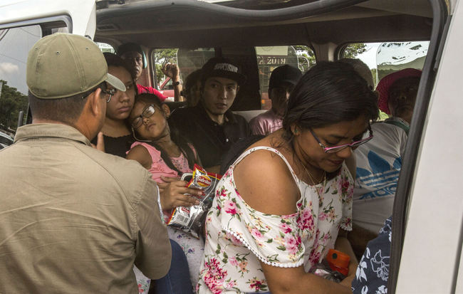 A Mexican migration agent, left, checks passengers' documents at an immigration checkpoint in Arriaga, on Mexico's southern border, Sunday, June 23, 2019. [Photo: AP/Oliver de Ros]