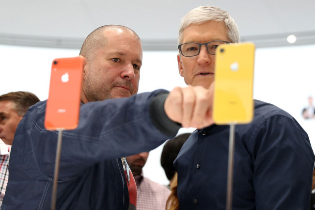 In this file photo taken on September 12, 2018 Apple chief design officer Jony Ive (L) and Apple CEO Tim Cook inspect the iPhone XR during an Apple special event at the Steve Jobs Theatre in Cupertino, California. [File Photo: AFP / JUSTIN SULLIVAN / GETTY IMAGES NORTH AMERICA]