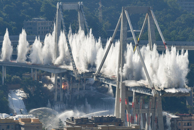 Explosive charges blow up the eastern pylons of Genoa's Morandi motorway bridge on June 28, 2019 in Genoa. Some of the remains of Genoa's Morandi motorway bridge were destroyed on June 28 almost eleven months after its partial collapse during a storm killed 43 people and injured dozens. [Photo: AFP/Vincenzo Pinto]