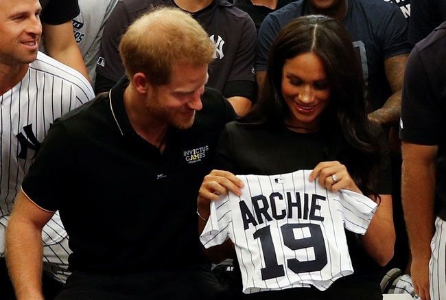 Britain's Prince Harry, Duke of Sussex, and his wife Meghan, Duchess of Sussex react as they are presented with gifts for her newborn son Archie, as they meet New York Yankees players ahead of their match against the Boston Red Sox at the London Stadium in Queen Elizabeth Olympic Park, east London on June 29, 2019, for the first of a two-game Baseball series in London. [Photo: AFP]