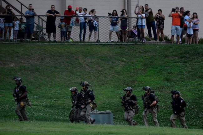 People watch as members of a Secret Service counter-assault team run from a helicopter to join a motorcade as Marine One lands with US President Donald Trump in Seoul on June 29, 2019. US President Donald Trump landed in South Korea on June 29, after inviting Kim Jong Un, the leader of nuclear-armed North Korea, to an impromptu meeting in the Demilitarized Zone that divides the peninsula. [Photo: AFP]