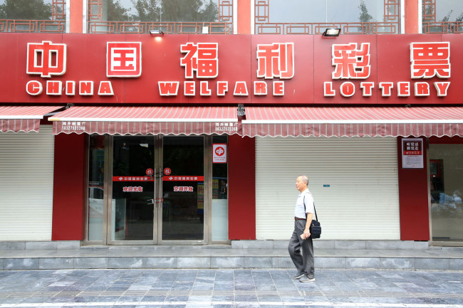 A man walks by a China Welfare Lottery station in Xiangyang, Hubei Province, on June 20, 2019. [Photo: IC]