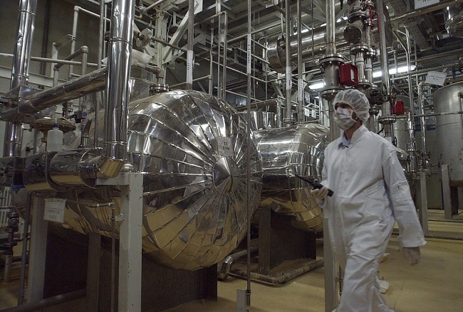 An Iranian security official in protective clothing walks through part of the Uranium Conversion Facility just outside the Iranian city of Isfahan. [File Photo: IC]