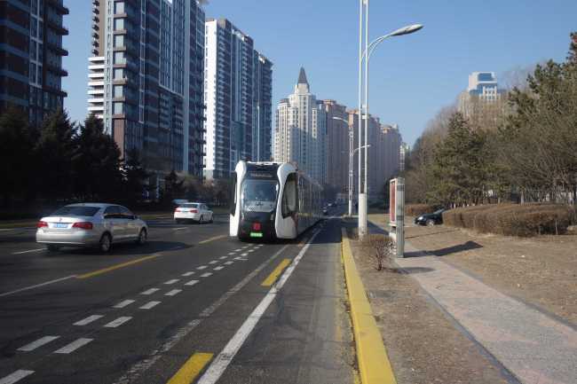 A railless train, developed by the CRRC Zhuzhou Institute Co. Ltd, runs on a new ART (Autonomous Rail Rapid Transit) line on a street during its trial operation in Harbin city, northeast China's Harbin province, March 2019. [File Photo: IC]<br>