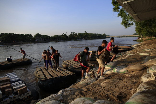 FILE - In this June 18, 2019 file photo, migrants arriving from Guatemala disembark from a raft in Ciudad Hidalgo, Mexico. Guatemala's office of the presidency said in a Sunday, July 14, 2019 statement that a meeting between Guatemala's President Jimmy Morales and U.S. President Donald Trump would be rescheduled due to legal appeals aimed at preventing Morales from acceding to Trump's requests to allow migrants, including non-Guatemalans, to remain in Guatemala while they apply for U.S. asylum instead of waiting at the Mexico-U.S. border. [Photo: AP/Rebecca Blackwell]