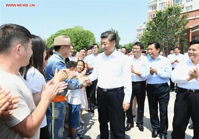 Chinese President Xi Jinping, also general secretary of the Communist Party of China (CPC) Central Committee and chairman of the Central Military Commission, shakes hands with residents of a community at Songshan District in Chifeng City, China's Inner Mongolia Autonomous Region, July 15, 2019. [Photo: Xinhua/Xie Huanchi]