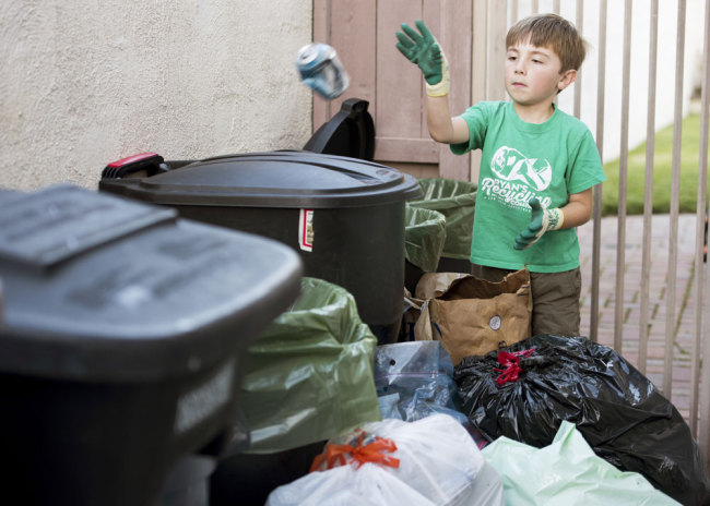 Ryan Hickman sorts recyclables he's collected from his neighbors in San Juan Capistrano, California, on Tuesday, February 28, 2017. [File Photo: IC]