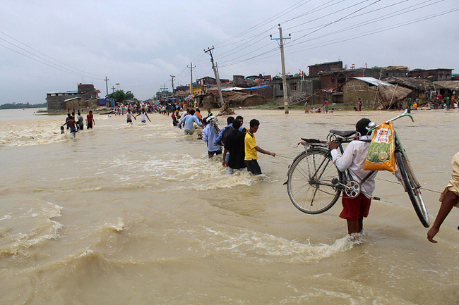 People use a rope to cross a river in the Gaur district of Rautahat, some 200km south of the capital Kathmandu, Nepal, on July 17, 2019 as annual heavy monsoon rains flooded the area. [Photo: VCG/AFP/Phani Mahat]