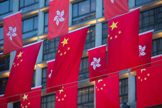 The national flag of China and the regional flag of the Hong Kong Special Administrative Region hang in a display in Hong Kong. [File photo: Bloomberg via Getty Images via VCG/Anthony Kwan]