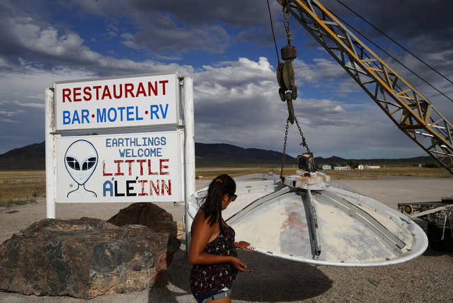 In this July 22, 2019 photo, Grace Capati looks at a UFO display outside of the Little A'Le'Inn, in Rachel, Nev., the closest town to Area 51. [Photo: AP]