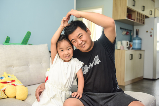 Cartoonist Cheng Peng is pictured with his daughter in Qingdao, Shandong Province on July 28, 2019. [Photo: IC]