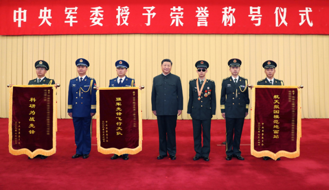 Xi Jinping (C), chairman of the Central Military Commission (CMC), poses for a group photo with a soldier and representatives of three military units during a CMC ceremony in Beijing, capital of China, July 31, 2019. Xi has signed orders to honor a soldier and three military units. At the ceremony on Wednesday, Xi hung a medal around the neck of Du Fuguo, who was awarded the title "Heroic Demining Soldier", and presented him with a certificate, and went on to confer honorary banners to representatives of the three units. [Photo: Xinhua]