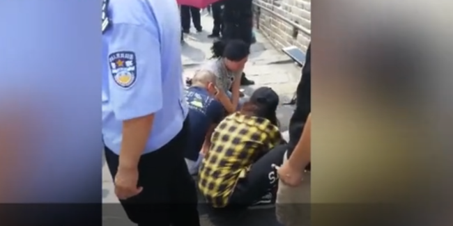 Screenshot of a video from yizhibo.com shows a group of Chinese people rescuing a 52-year-old female Japanese tourist who fainted(晕倒 yūndǎo) at the Badaling section of the Great Wall. [Photo: China Plus]