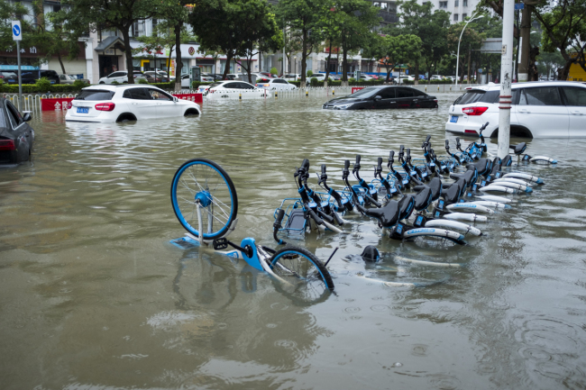 Bicycles and motorcycles are submerged on a flooded road after a heavy rainstorm caused by Typhoon Wipha, the 7th typhoon of the year, in Haikou, capital of Hainan province, August 1, 2019. [Photo: IC]