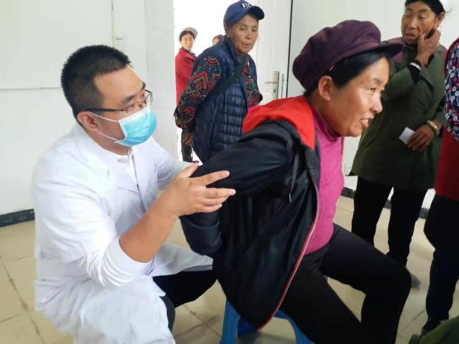 Doctor Lv is seeing a patient who has been suffering from back pain for two years. [Photo: China Plus]