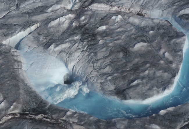 In this image taken on Thursday Aug.1, 2019 large rivers of melting water form on an ice sheet in western Greenland and drain into moulin holes that empty into the ocean from underneath the ice. [Photo: AP]