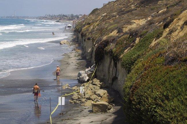 The area where Friday's sea cliff collapsed killing three people is taped off near the Grandview Beach access stairway in the beach community of Leucadia, Saturday, Aug. 3, 2019, in Encinitas, Calif. A 30-foot-long hunk of the cliff in San Diego County collapsed Friday afternoon. Rescuers rushed to dig out victims, but a woman died at the scene and two more victims died at hospitals. [Photo: AP/Hayne Palmour IV/The San Diego Union-Tribune]