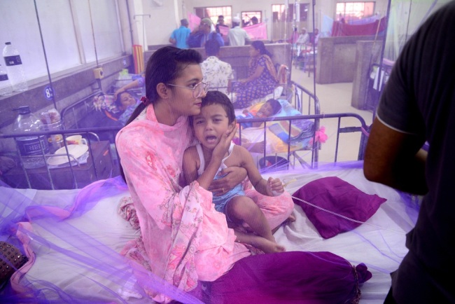 A mother holds her child in a hospital as he suffering from dengue fever in Dhaka, Bangladesh, on August 3, 2019. More than 20 thousands people have been infected with the mosquito-borne disease according to the Directorate General of Health Services (DGHS), in Bangladesh. [Photo: ZUMA Press via IC]