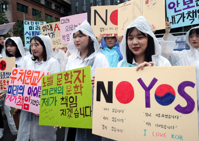 South Korean people hold placards and call for a boycott of Japanese products during an anti-Japan rally in Seoul, South Korea, July 26, 2019. [Photo: Yonhap News via IC]