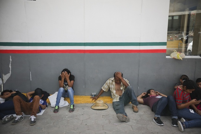 Migrants rest near a Mexican immigration center where people have set up a camp to sleep in Matamoros, Mexico, Thursday, August 1, 2019, on the border with Brownsville, Texas. [File Photo: AP via IC/Emilio Espejel]