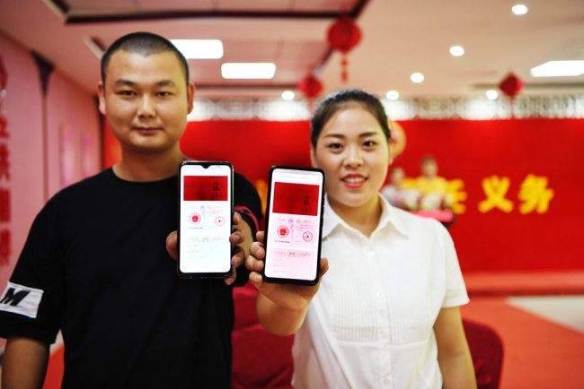 A couple shows their digital marriage certificates on their smartphones in Jiangxi Province on the Qixi Festival, also known as the Chinese Valentine's Day, on Wednesday, August 7, 2019. [Photo: IC]