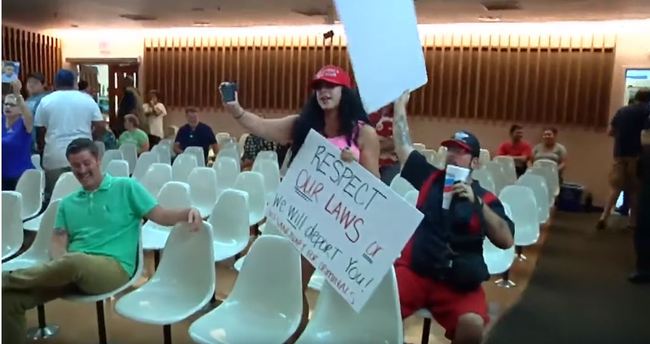 This screeshot of a video shows Alex Kack, in the green shirt at left, laughing at a protester during a vote to put a "sanctuary city" initiative on the November ballot during a meeting of the Tucson, Ariz., City Council Tuesday, Aug. 6. [Photo: Screenshot]