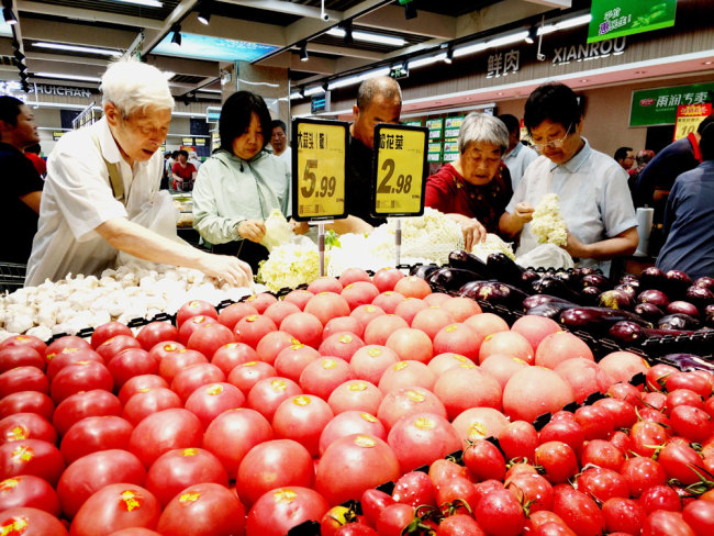 Consumers select vegetables at a supermarket in Nantong, Jiangsu Province. [File photo: IC]