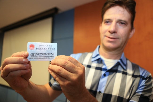 A high-quality foreign worker shows his foreign permanent resident ID card in Xi’an, northeast China’s Shaanxi Province, on September 8, 2017. [File Photo: VCG] 