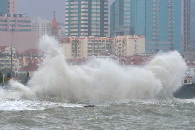 Huge waves from a tidal bore caused by the Typhoon Lekima, the 9th typhoon of the year, surge past the banks along the seacoast in Qingdao city, east China's Shandong province, August 11, 2019. [Photo: IC]