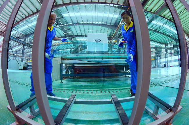 Workers making vacuum glass at a glazing product manufacturer in Ganzhou City, Jiangxi Province, August 9, 2019. [Photo: IC]<br>