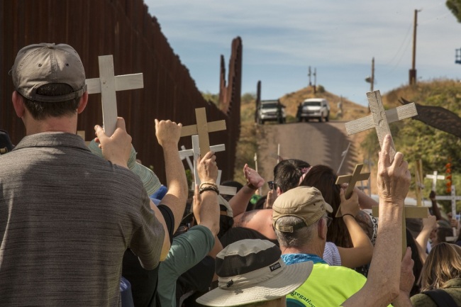 A rally held on both sides of the U.S.-Mexico border fence remembers migrants who have died trying to cross the border. [File Photo: IC]