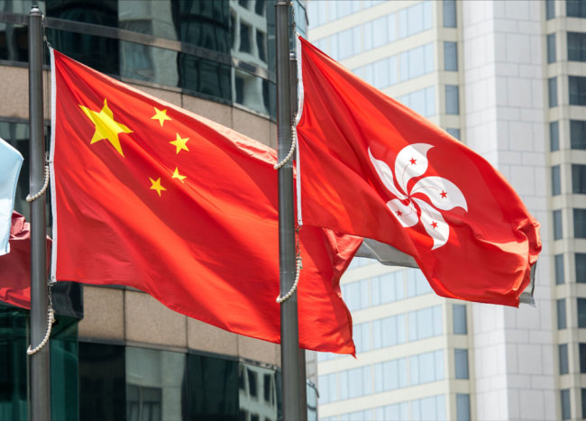 The Chinese national flag and the flag of the Hong Kong Special Administrative Region flutter in Hong Kong. [File Photo: IC]