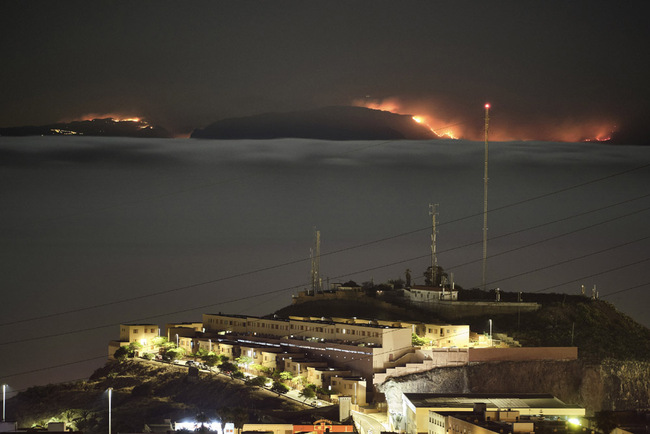 The fire on the mountains of the Canary Islands in this view taken from Santa Cruz de Tenerife island, Spain, early Monday, Aug. 19, 2019. Authorities on Spain's Canary Islands say around 4,000 people have been evacuated due to a wildfire that has ravaged more than 1,700 hectares (4,200 acres) since it broke out a day ago. [Photo: AP/Andres Gutierrez]