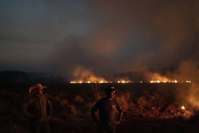 Neri dos Santos Silva, center, watches an encroaching fire threat after digging trenches to keep the flames from spreading to the farm he works on, in the Nova Santa Helena municipality, in the state of Mato Grosso, Brazil, Friday, Aug. 23, 2019. [Photo: IC/AP Photo/Leo Correa]