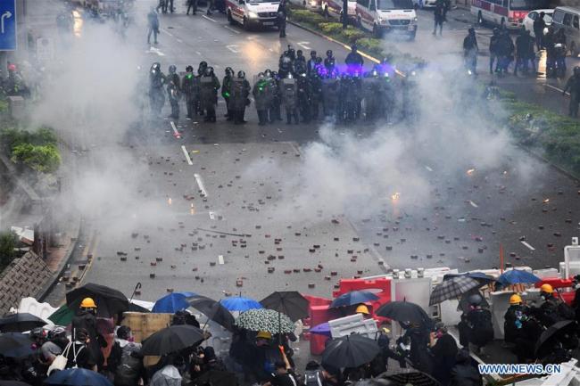 Radical protesters confront with police officers in Tsuen Wan, in the western New Territories of south China's Hong Kong, Aug. 25, 2019. Radical protesters block various roads, hurl bricks and stones at police officers in the protest. [Photo: Xinhua/Qin qing]