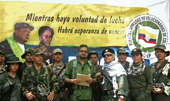 This TV grab taken from Youtube and released on August 29, 2019 shows former senior commander Ivan Marquez(C) and fugitive rebel colleague, Jesus Santrich (wearing sunglass), of the dissolved FARC rebel army group in Colombia, announcing that they are taking up arms again. [Photo: AFP]