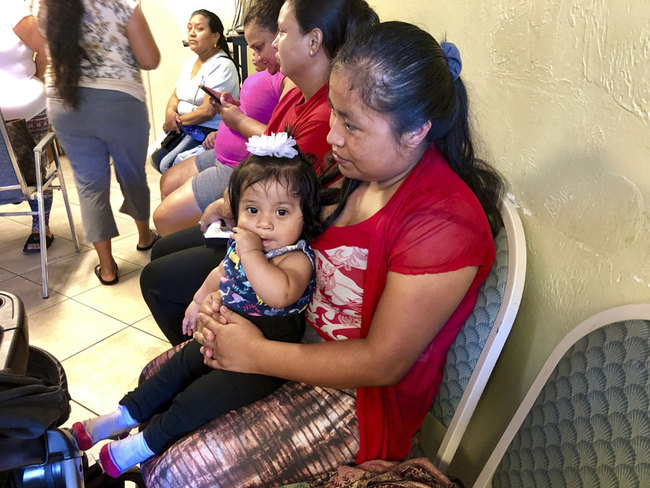 Amalia Godinez sits her 10-month-old daughter Priscila on her lap as she waits for help at the Guatemalan-Maya Center on Friday, Aug. 30, 2019 in Lake Worth, Fla. [Photo: AP/Adriana Gomez]