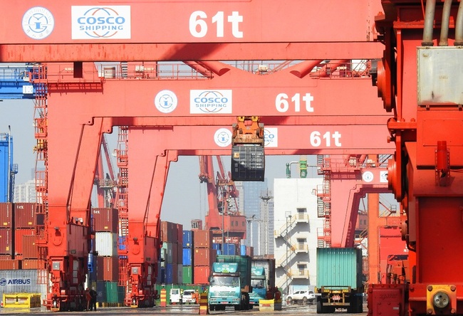 A crane vehicle lifts a container to be shipped abroad from a truck on a quay at the Port of Lianyungang in Lianyungang city, east China's Jiangsu province, May 8, 2019. [File Photo: IC]