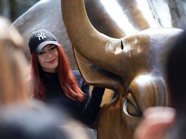 A visitor at the popular lower Manhattan sculpture "Charging Bull" poses for a photo next to the sculpture's damaged horn Sunday, Sept. 12, 2019, in New York. [Photo: AP]