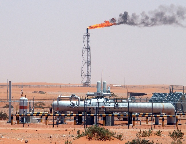 An image showing a gas flame behind pipelines in the desert at Khurais oil field, about 160 km from Riyadh, Kingdom of Saudi Arabia, June 23, 2008. [File Photo: IC]