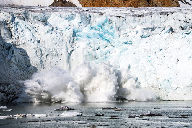 A picture taken on August 17, 2019 shows an iceberg calving with a mass of ice breaking away from the Apusiajik glacier, near Kulusuk (aslo spelled Qulusuk), a settlement in the Sermersooq municipality located on the island of the same name on the southeastern shore of Greenland. [Photo: AFP]